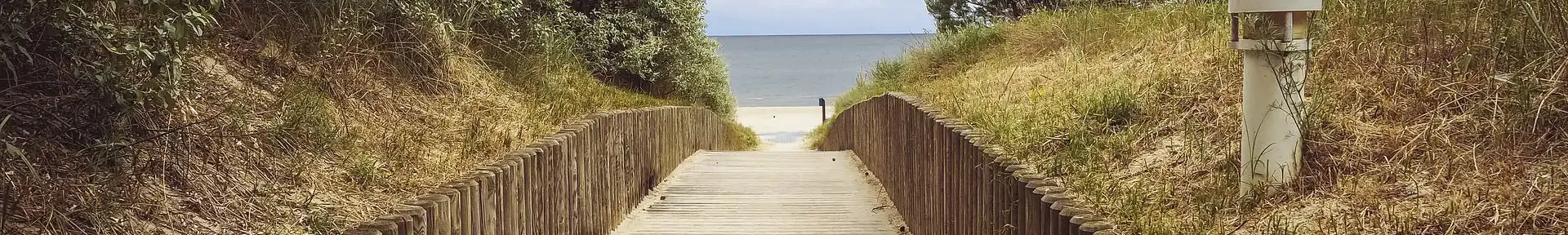 Weg aus Holz zum Ostsee-Strand mit Dünen an den Seiten